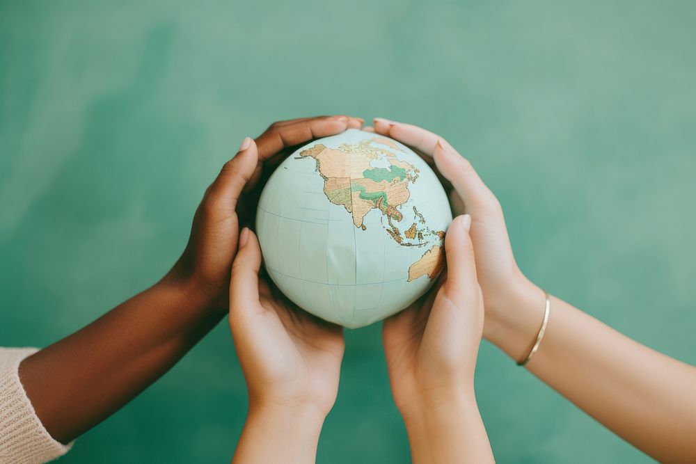 3 people hands holding a paper craft Globe globe planet togetherness.