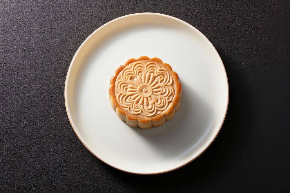 A chinese mooncake cut open arranged put on plate dessert icing food.