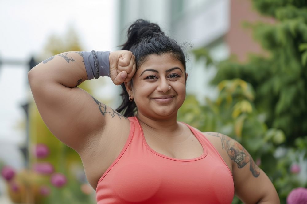 Fat south asian woman flexing muscle smile sports tattoo.