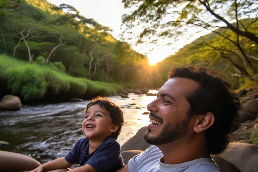 Brazilian dad spend time with son landscape laughing outdoors.