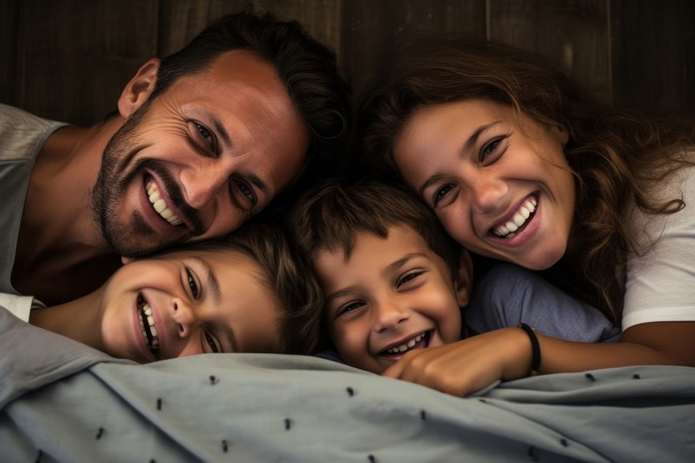 Latin Happy family lying on bed laughing adult happy.