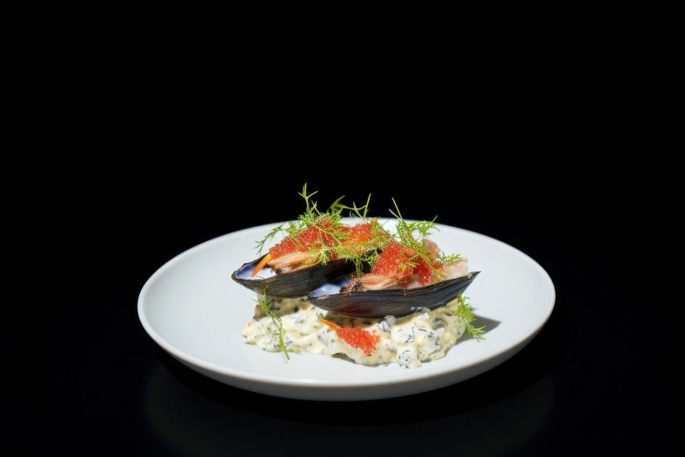 Mussels on top with caviar plate food meal.