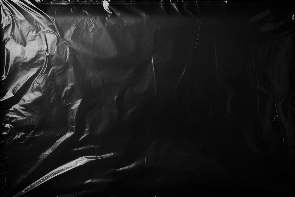 Transparent plastic wrap over black background backgrounds monochrome darkness.