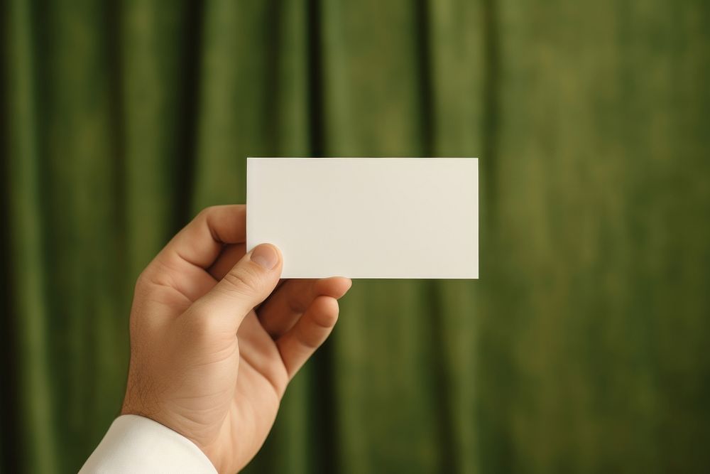 Bussiness card  holding green paper.
