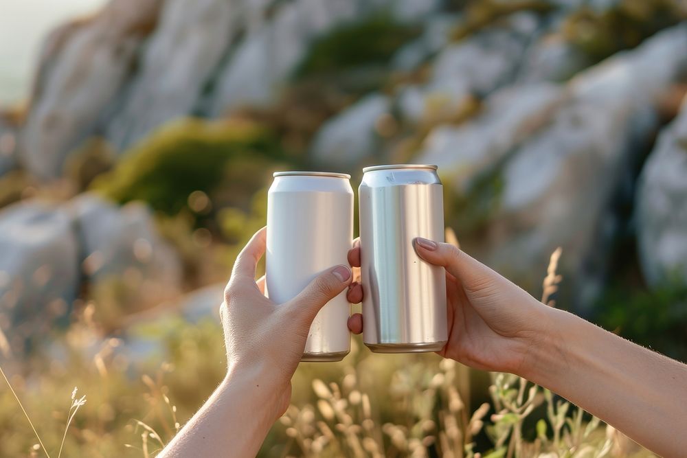 Stainless can  outdoors holding drink.