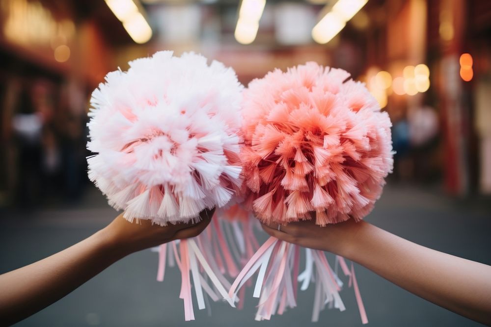 Two cheerleaders hands holding pom poms flower celebration happiness.