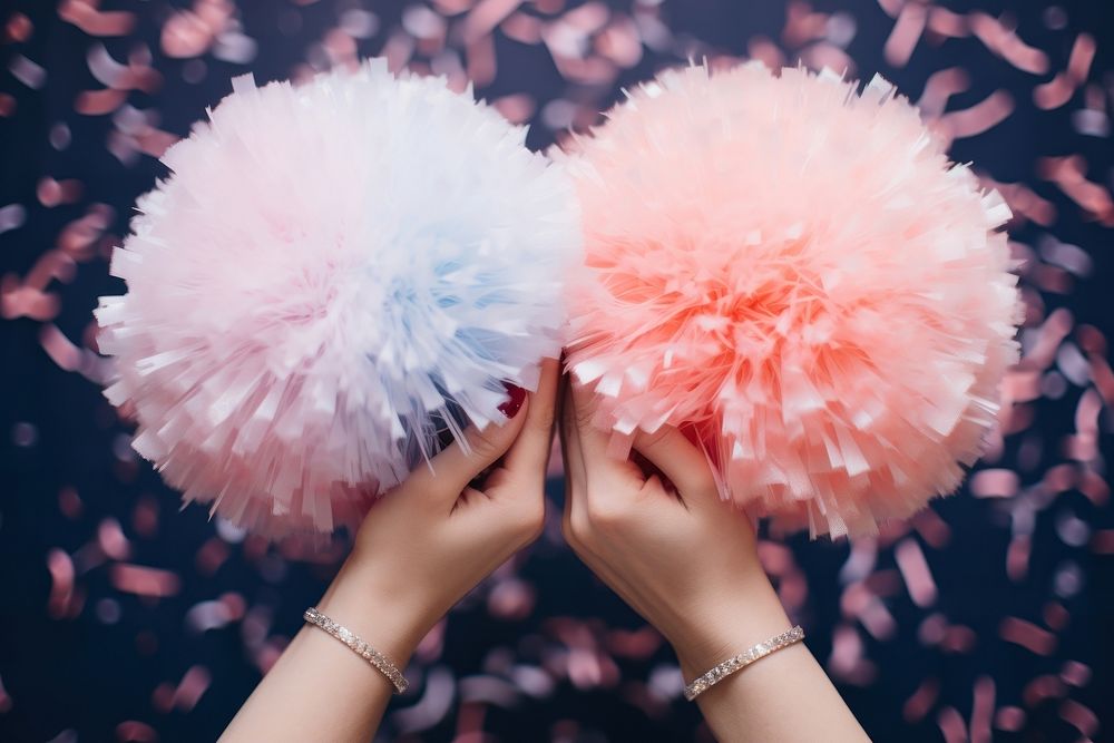 Two cheerleaders hands holding pom poms adult celebration decoration.