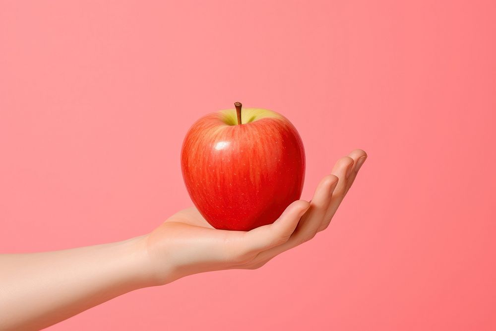 Apple on hand holding fruit plant.