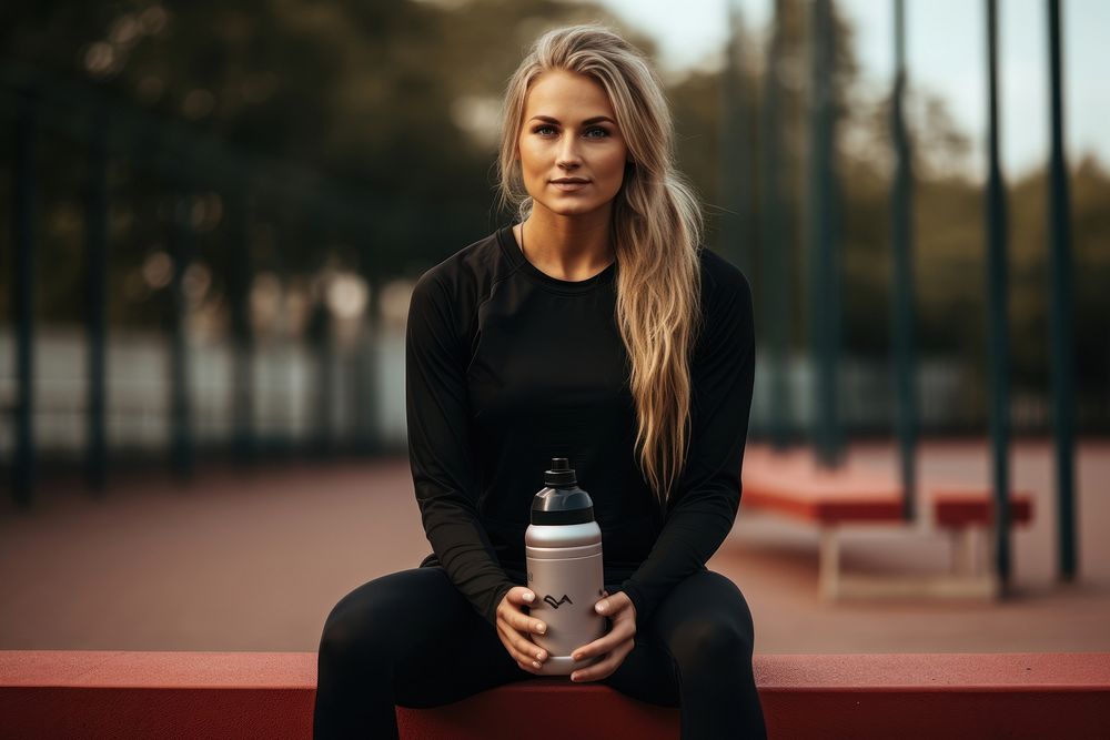Athletic woman sitting on a bench portrait bottle adult.