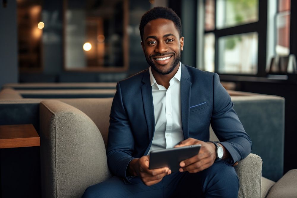 Business black man sitting and holding tablet smiling adult relaxation.