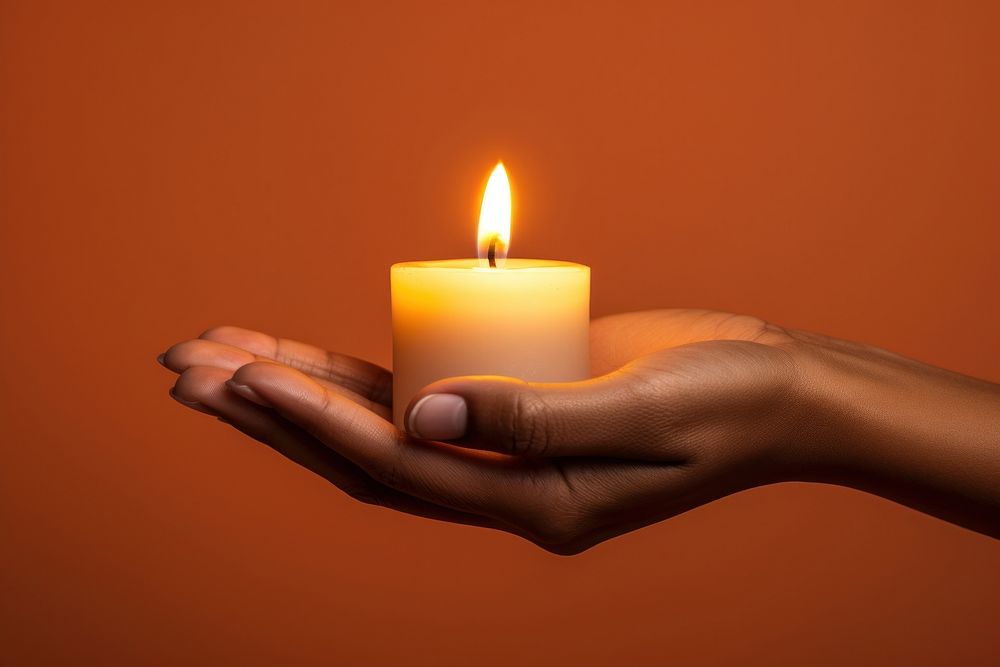 Candle holding adult hand.