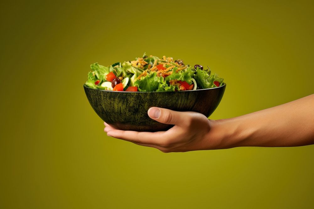 Salad bowl on hand holding food vegetable.