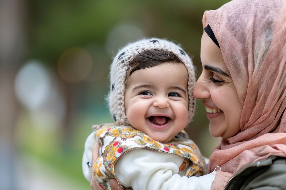 Middle eastern baby laughing with her mom smiling adult love.