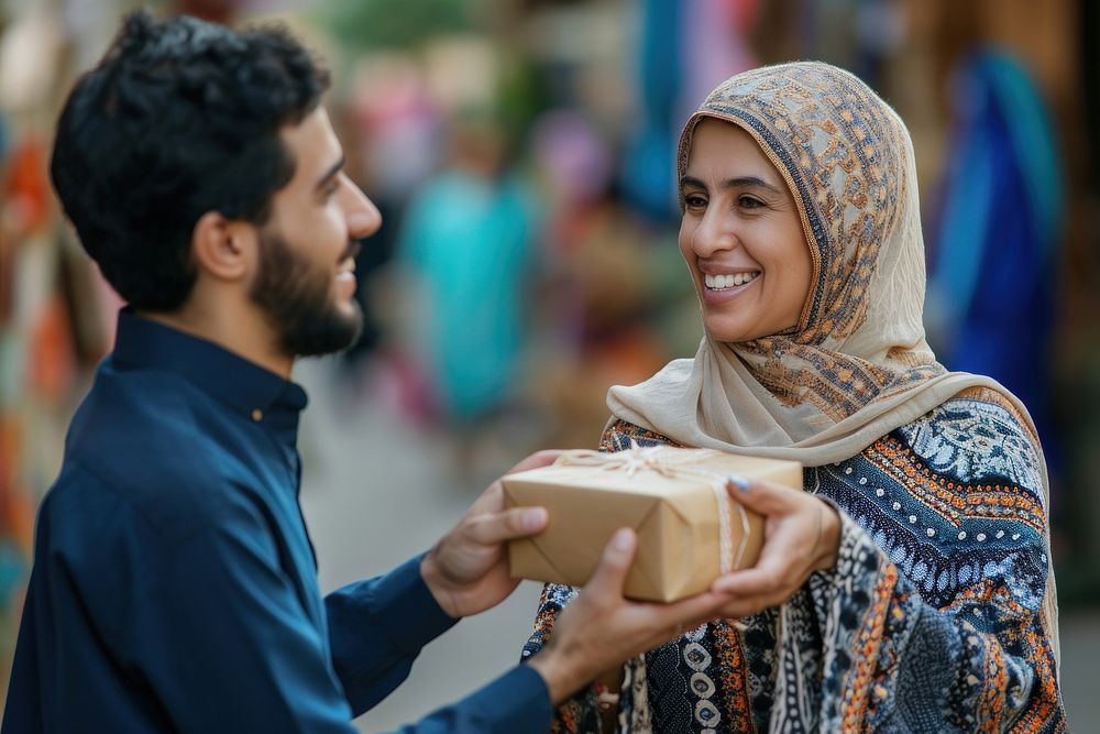 Middle eastern son giving gift to his mother smiling adult love.