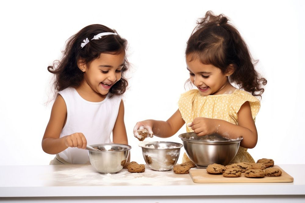 Young girl making cookies with her friend eating child bowl.