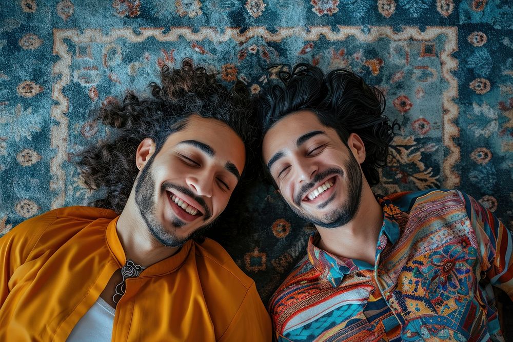 Middle eastern gay couple laying on the floor laughing smiling smile.