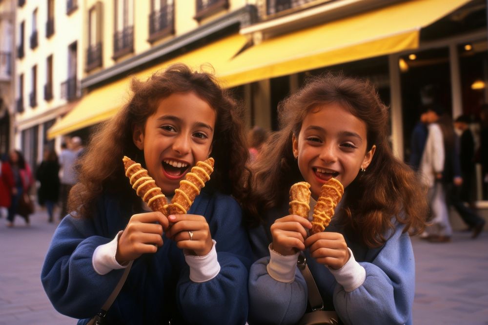 Two spanish girls eating churros dessert adult child.