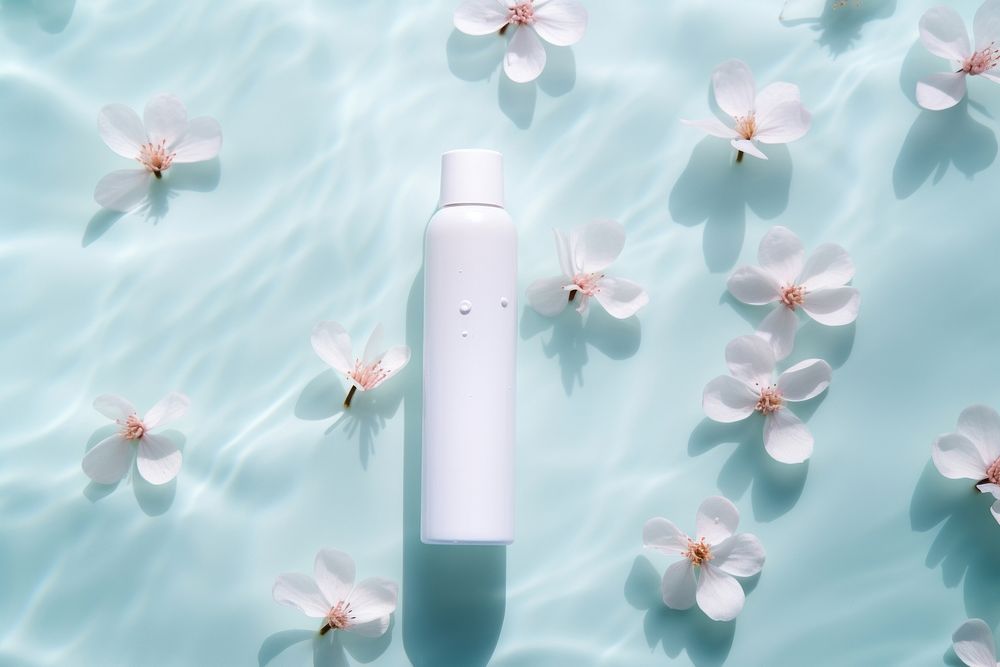 White dropper bottle on water floor pattern cosmetics outdoors blossom.