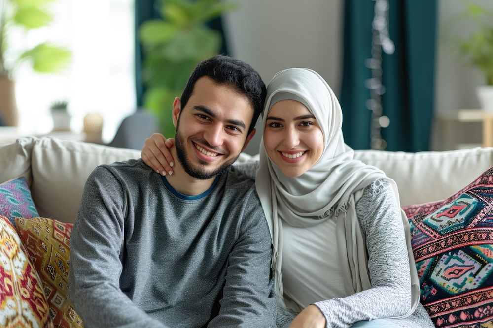 Middle eastern couple sitting on couch smiling adult scarf.
