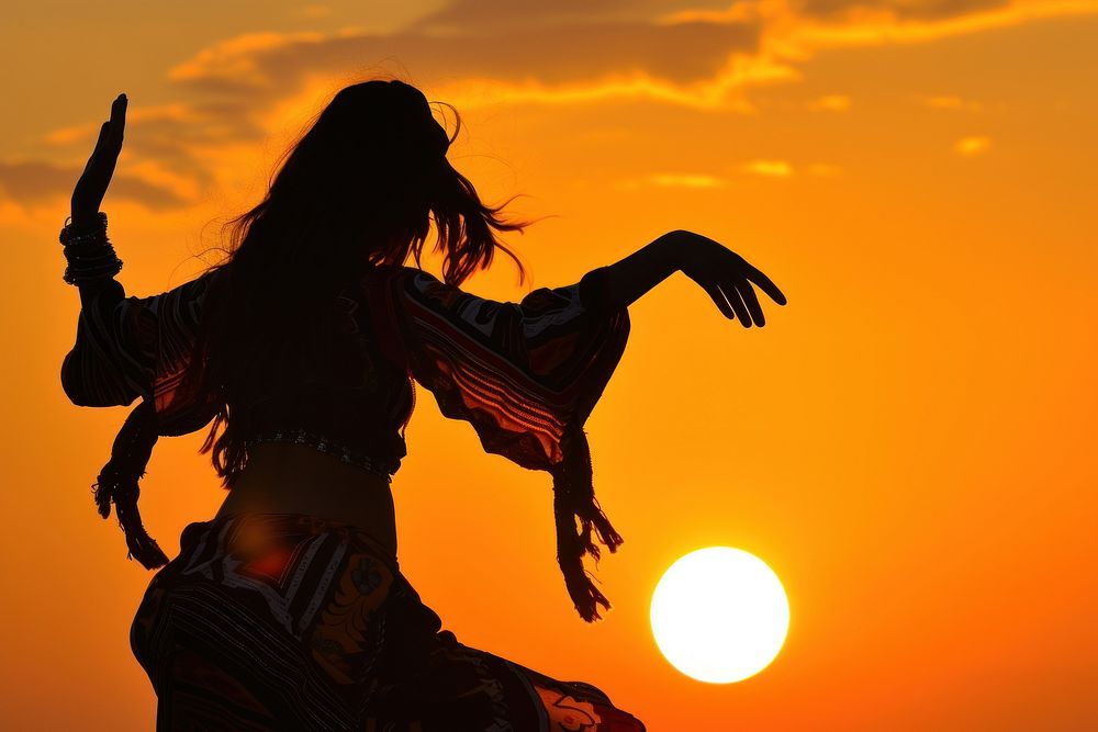 Middle Eastern girl dancing backlighting outdoors sunset.