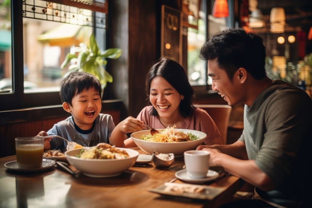Thai family eat noodle restaurant father child.