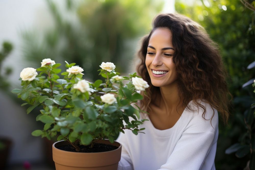 Woman and a rose plant pot outdoors smiling flower.