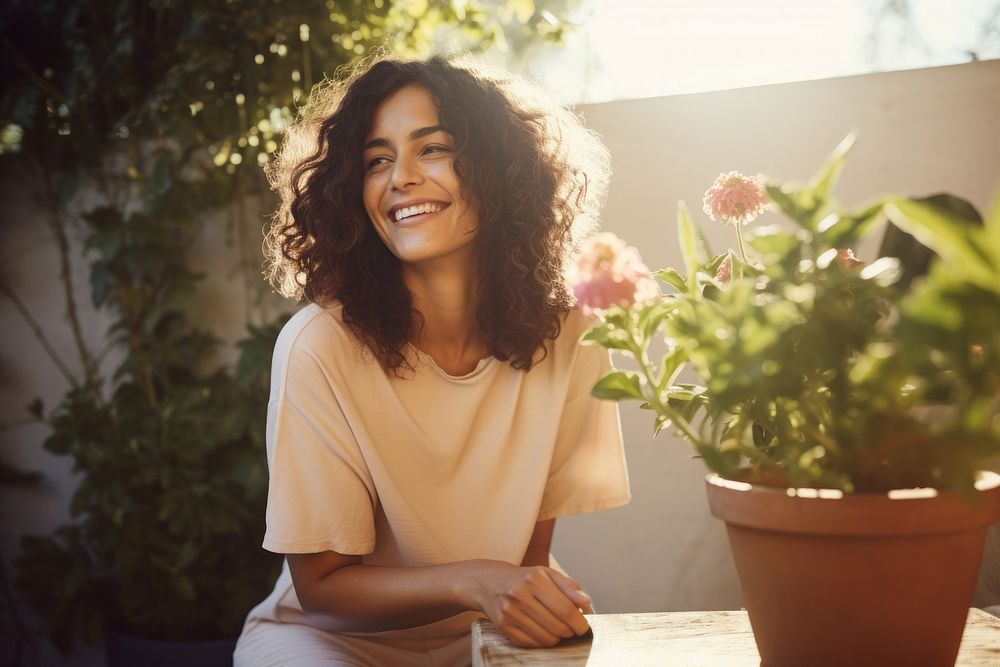 Woman and a rose plant pot outdoors smiling smile.