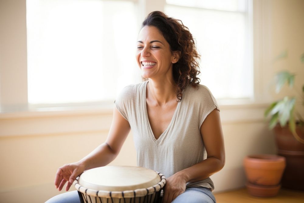 Hispanic woman playing drum musician smile drums.