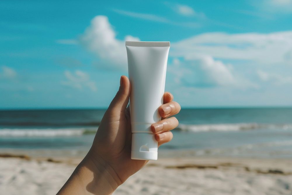 Cream tube holding beach hand.