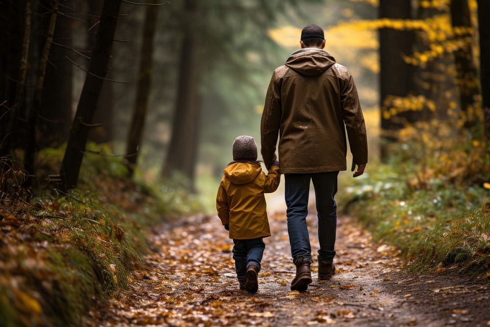 A man and child walking through a woods plant adult hand.