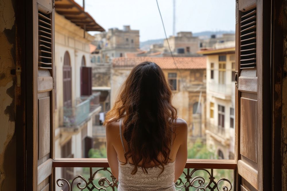 Lebanese female tourist looking at old town balcony architecture building.