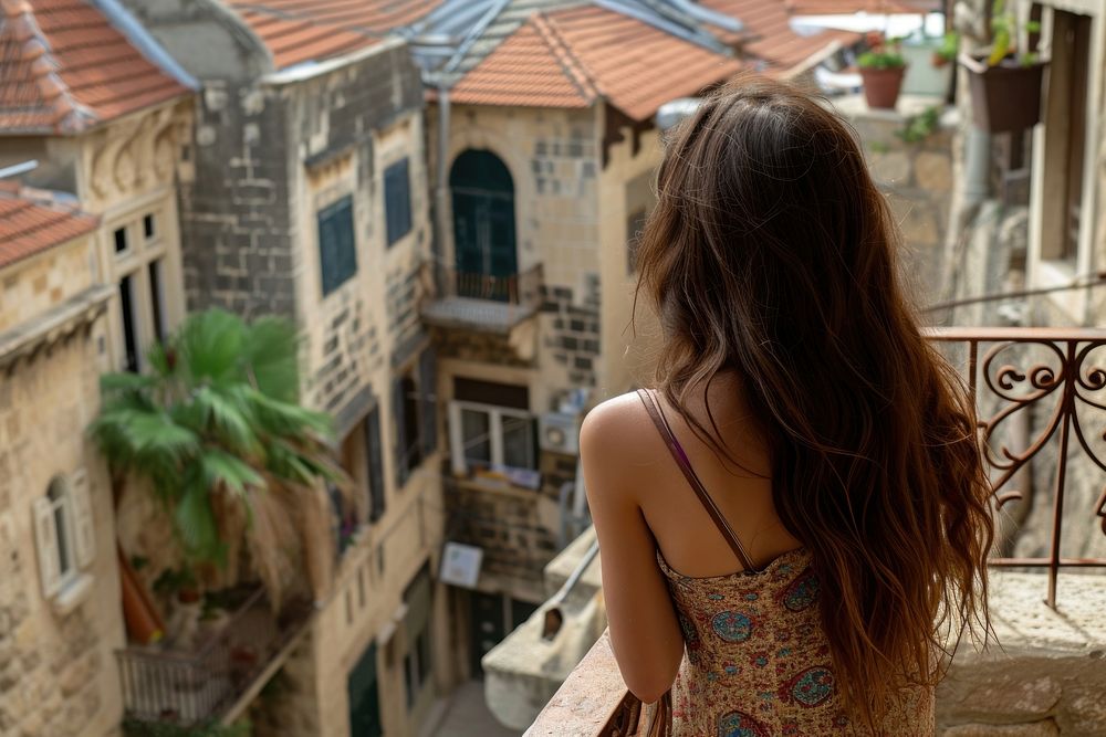 Lebanese female tourist looking at old town balcony city neighbourhood.