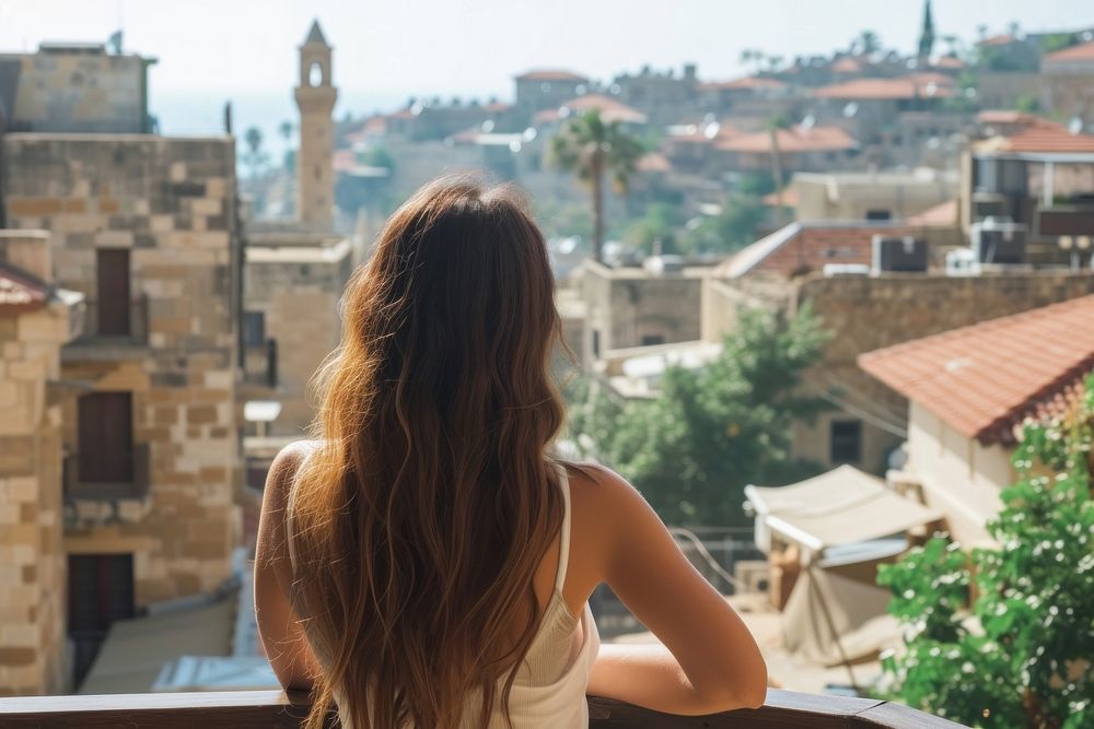 Lebanese female tourist looking at old town architecture cityscape building.