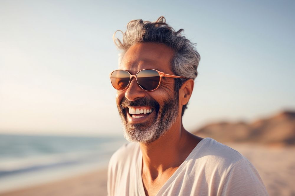 Mature middle eastern man enjoying summer at the beach laughing smiling adult.