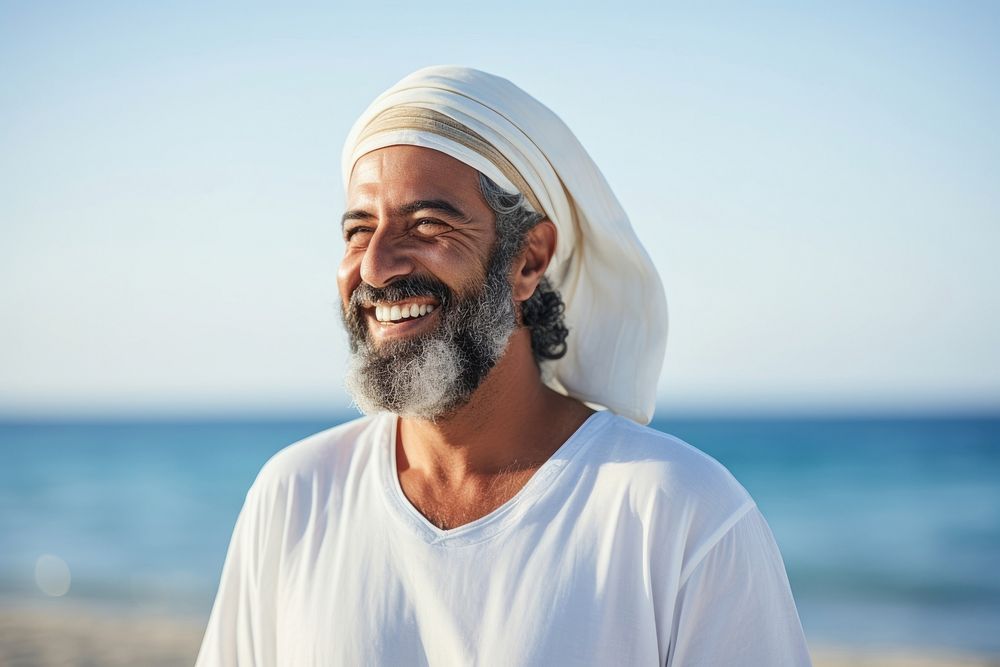 Mature middle eastern man enjoying summer at the beach smiling adult smile.