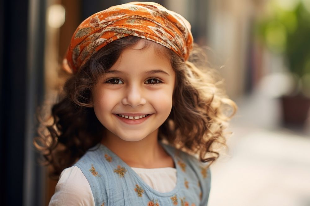 Middle eastern little girl in summer outfit portrait smiling scarf.