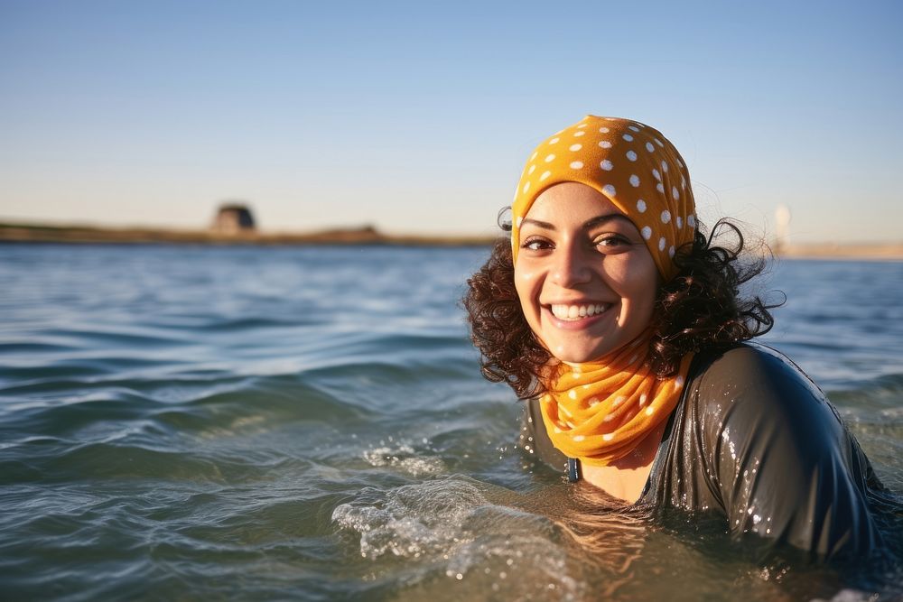 Middle eastern woman swimming portrait outdoors smiling.