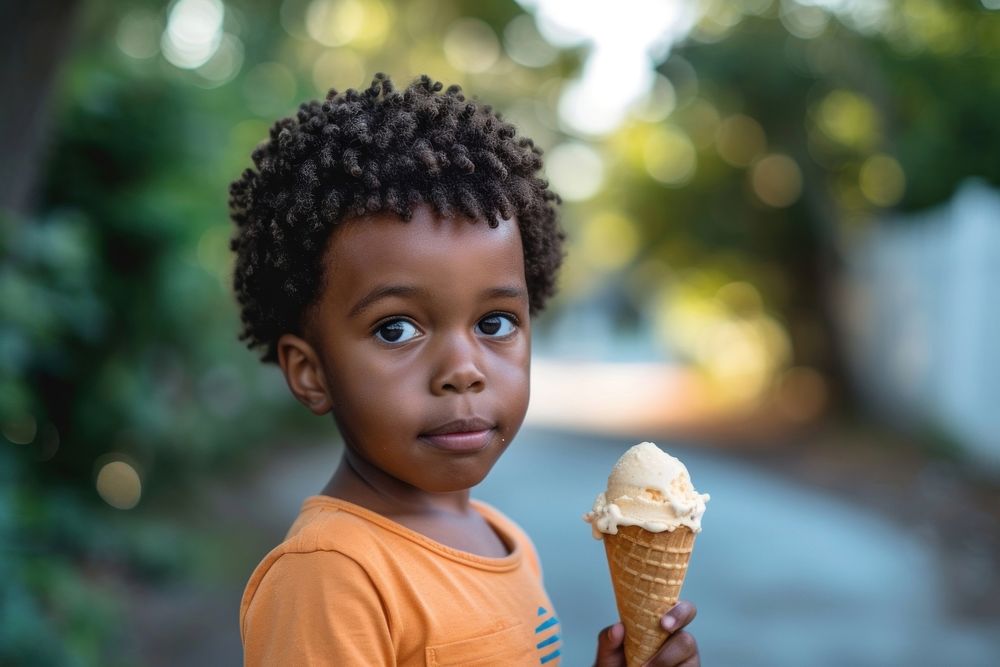 A little boy holding an ice cream cone dessert food hairstyle.