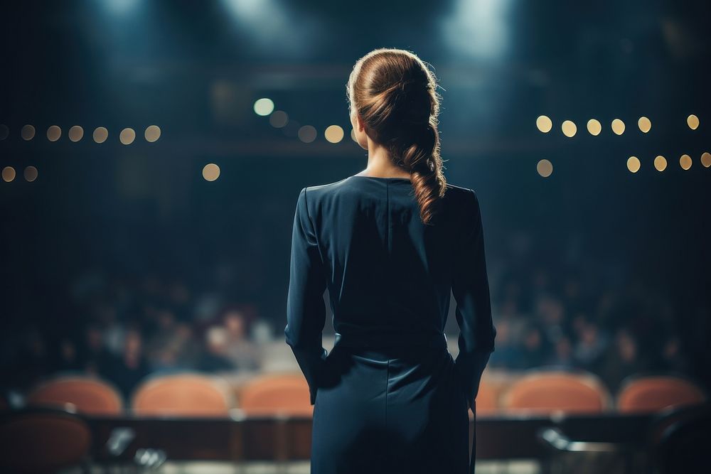 A woman in formal outfit talking in the stage adult light illuminated. AI generated Image by rawpixel.