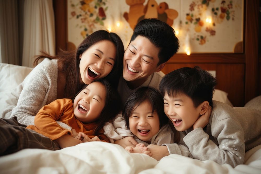 Happy Asian family lying laughing bedroom happy.