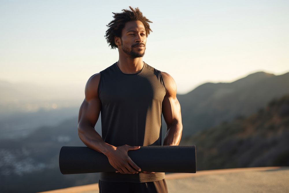 A black woman holding a yoga mat outdoors person adult. 