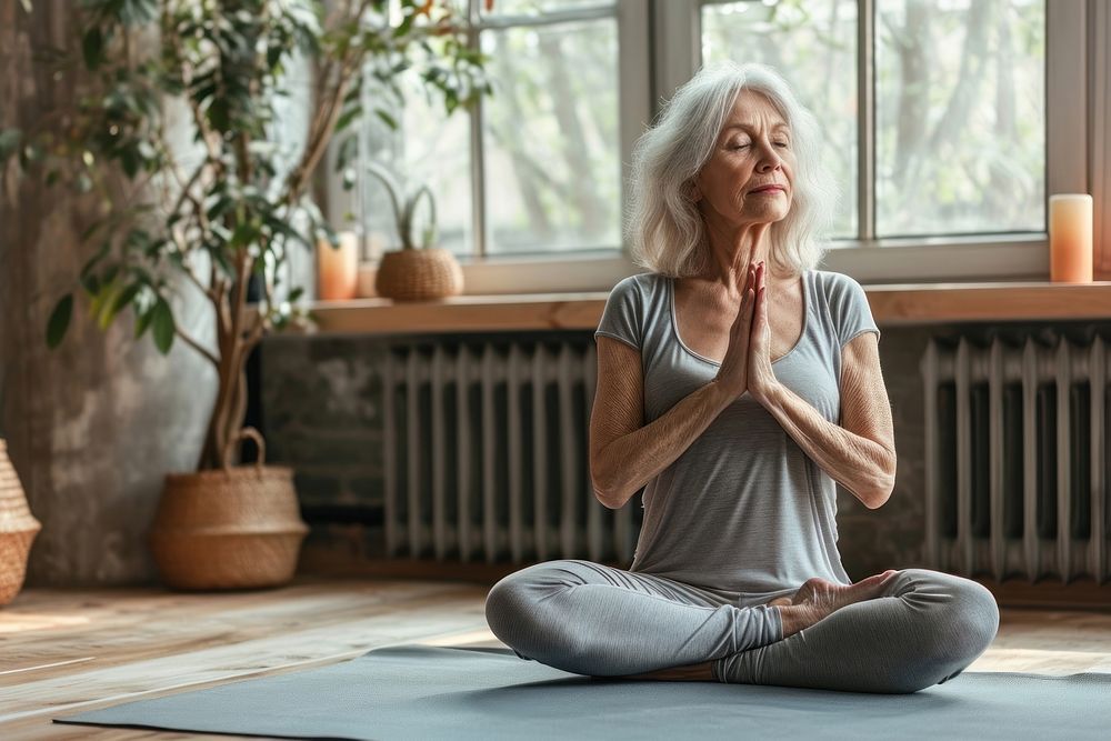 A senior woman in a yoga class meditating adult contemplation concentration. AI generated Image by rawpixel.
