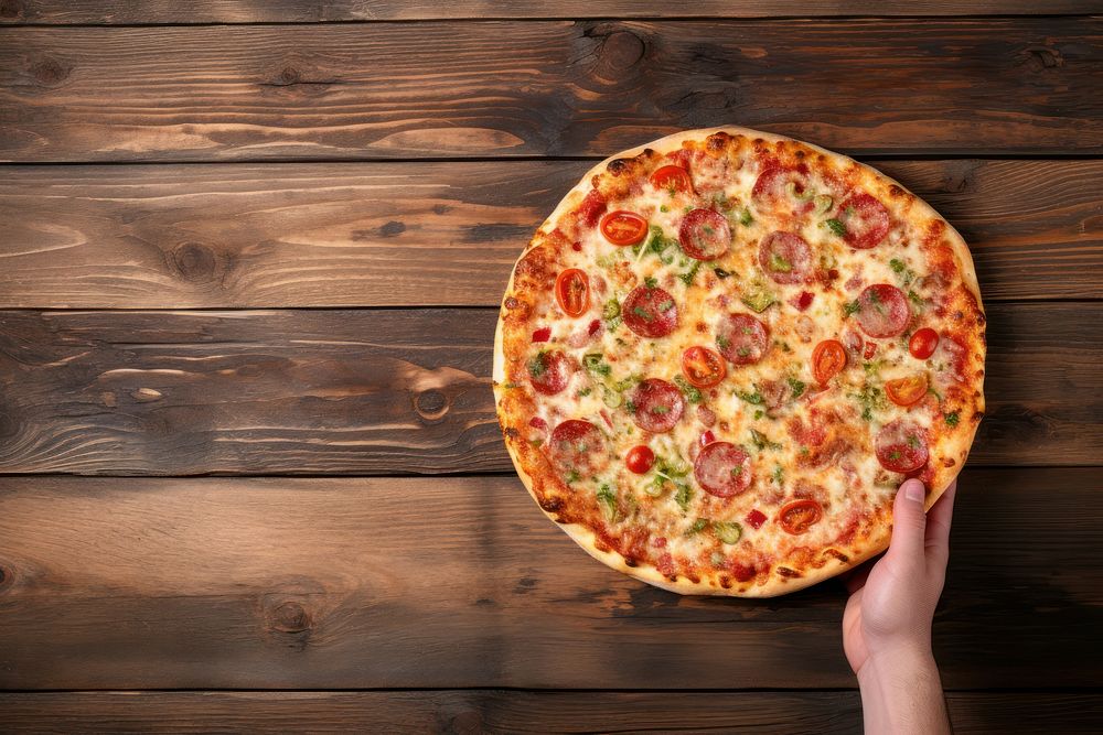 Hand holding tasty flavorful pizza food pepperoni vegetable.