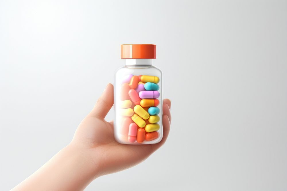 A hand holding a medicine bottle filled with colorful medicine capsules pill white background confectionery. AI generated…