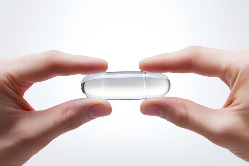 Two fingers holding a clear gel capsule medicine pill medication. AI generated Image by rawpixel.