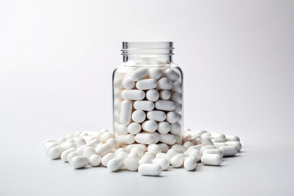 A medicine bottle filled with white medicine capsules pill jar white background. AI generated Image by rawpixel.