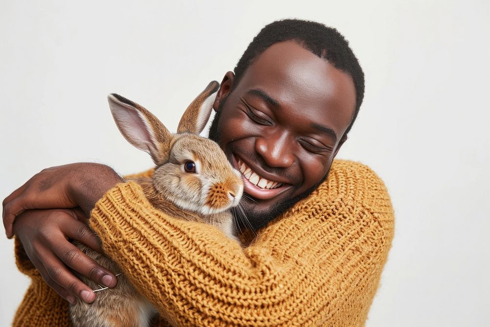African-American man hugging a rabbit portrait animal mammal.