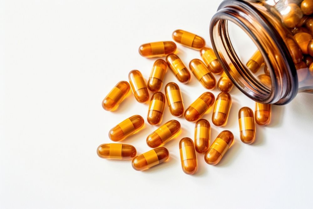 Medicine capsules in an opened bottle pill white background medication. AI generated Image by rawpixel.