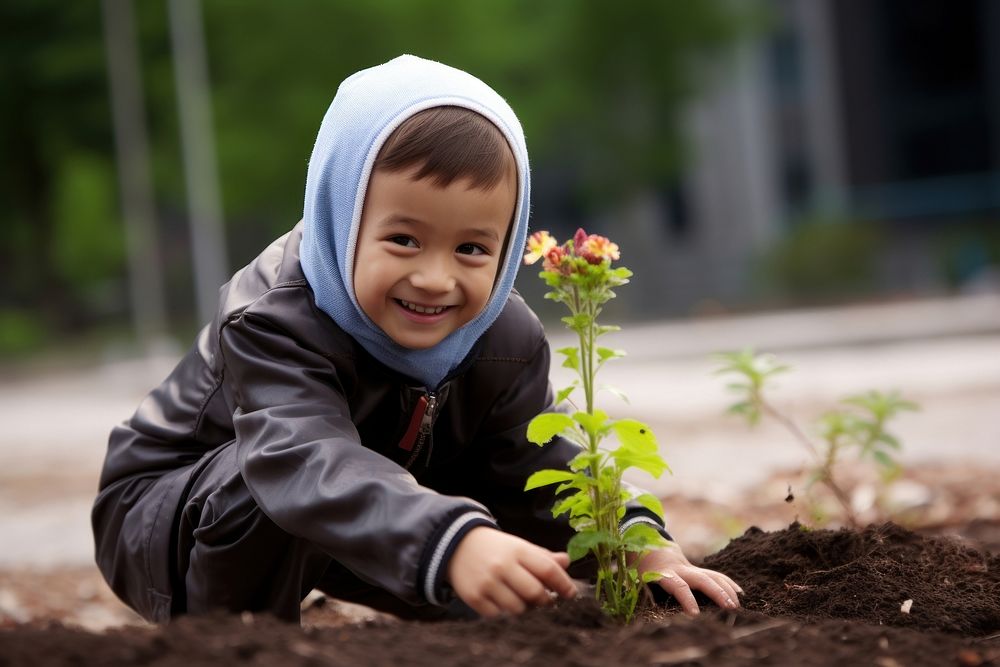 Malaysian kid gardening planting outdoors.