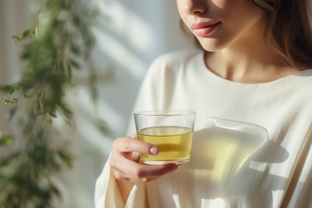 Woman sipping herbal tea glass drink contemplation. AI generated Image by rawpixel.